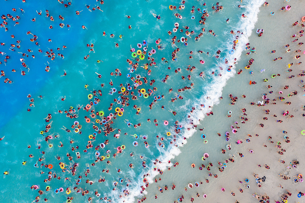 An aerial photo shows visitors enjoying waves in an artificial wave pool at a water park in Zhengzhou, Henan Province on July 22, 2026. /VCG
