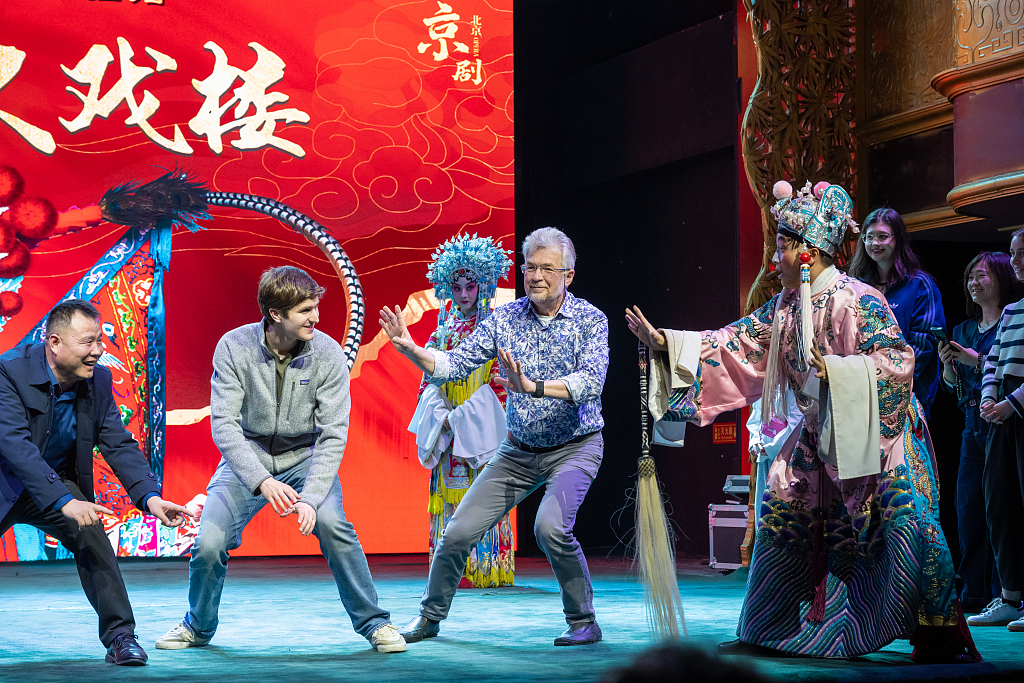 International visitors interact with Peking Opera performers at a cultural experience center on Qianmen Street, exploring the rich heritage of traditional Chinese opera, Beijing, capital of China, March 22, 2026. /CFP