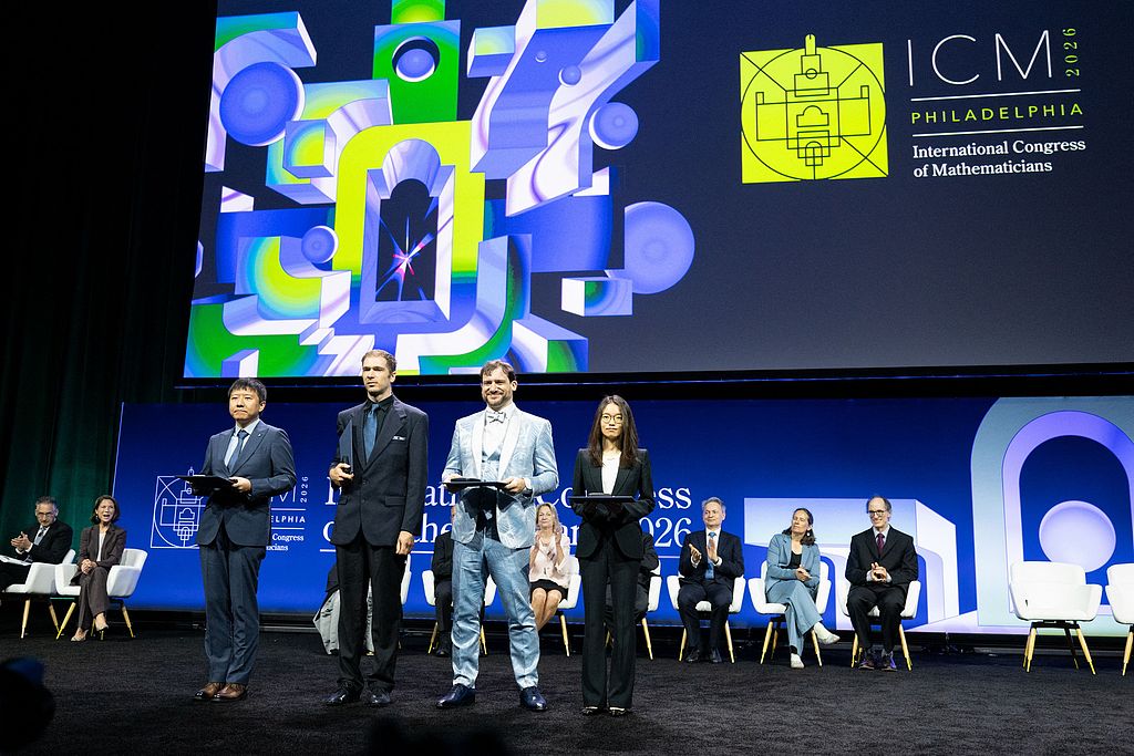 Four Fields Medal laureates pose for photos onstage after receiving their Fields Medals during the International Congress of Mathematicians in Philadelphia, July 23, 2026. /VCG