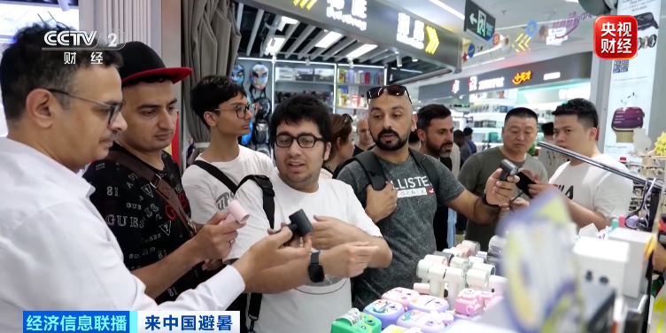 Foreign tourists shop for portable fans and other summer cooling gadgets at Shenzhen's Huaqiangbei electronics market, south China's Guangdong Province. /CMG