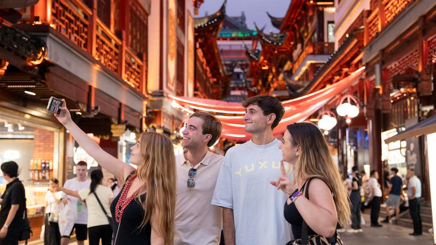 Tourists from Spain take a selfie at Yuyuan Garden Mall in Shanghai, east China, July 21, 2025. /Xinhua
