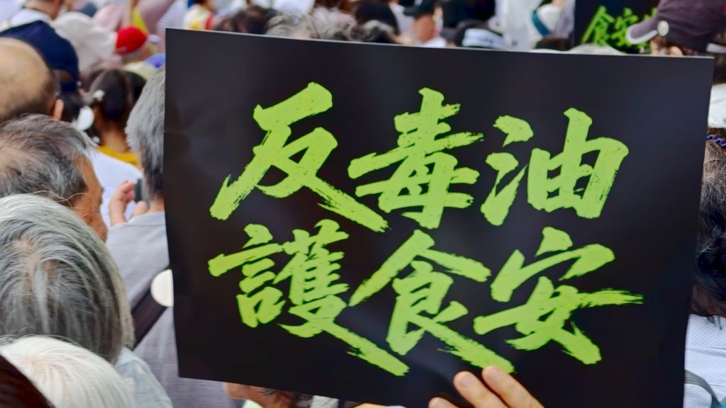 A demonstrator holds up a sign reading 