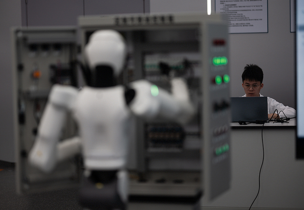 An employee trains a service robot at the Guangdong Power Grid robotics laboratory in Guangzhou, Guangdong Province, China, April 16, 2026. /VCG