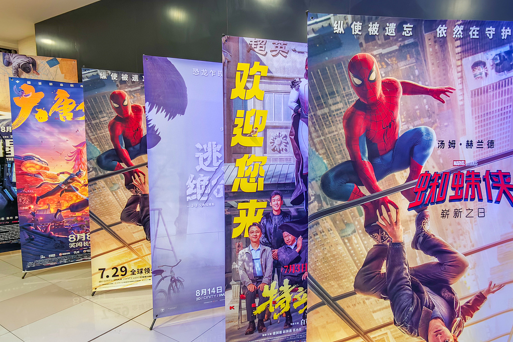 Visitors pose with men dressed as Spider-Man at a pop culture event in Shanghai on July 10, 2026. /VCG
