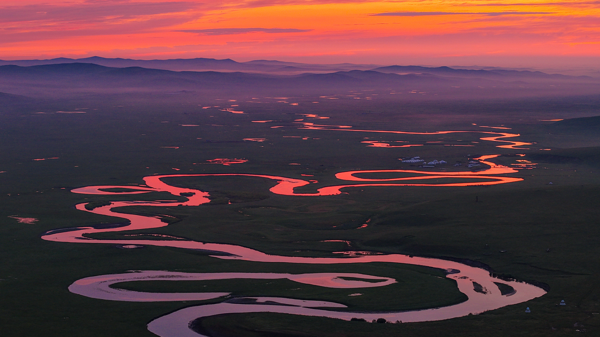 Sunrise colors the sky above a river as mist hangs over the grassland in Hulunbuir, north China's Inner Mongolia, July 27, 2026. /VCG