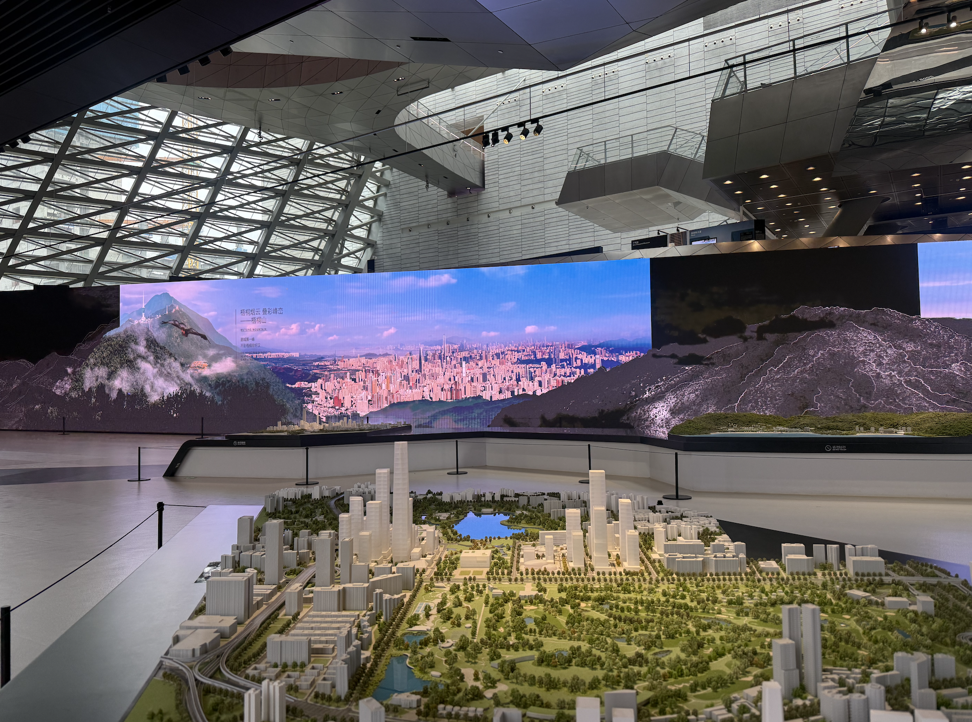 Inside MOCAUP, the urban planning model's centerpiece – Futian's skyline in miniature, ringed by a wraparound screen showing Wutong Mountain, the city's highest peak.