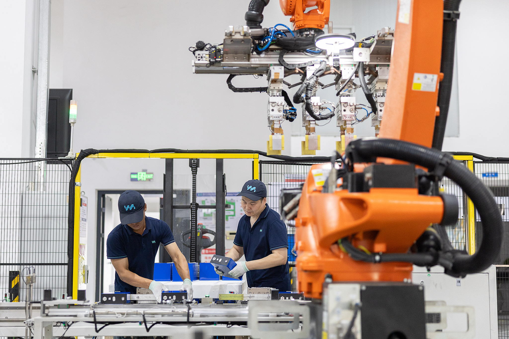Workers produce solid-state batteries as industrial robots operate on an automated production line in Huzhou, Zhejiang Province, China, July 8, 2026. /VCG