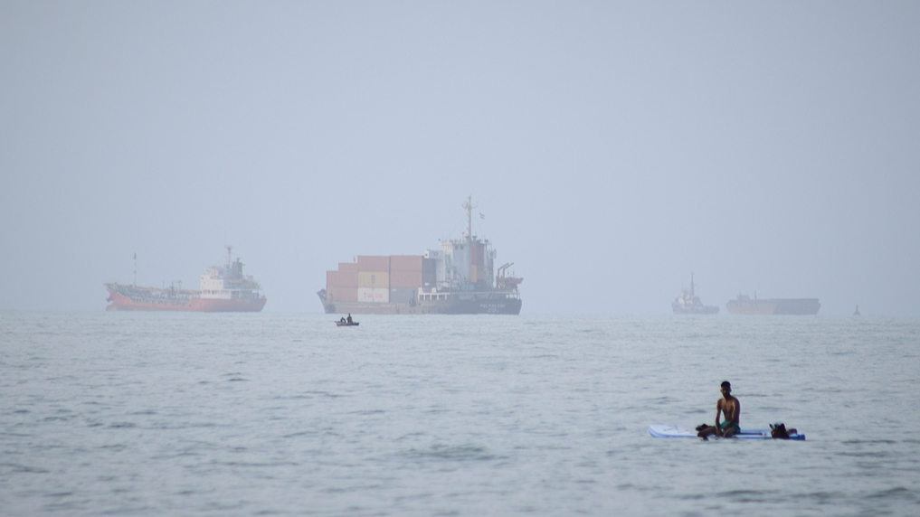 A container ship and other commercial vessels appear anchored in the Strait of Hormuz off Bandar Abbas, Iran, July 27, 2026. /VCG