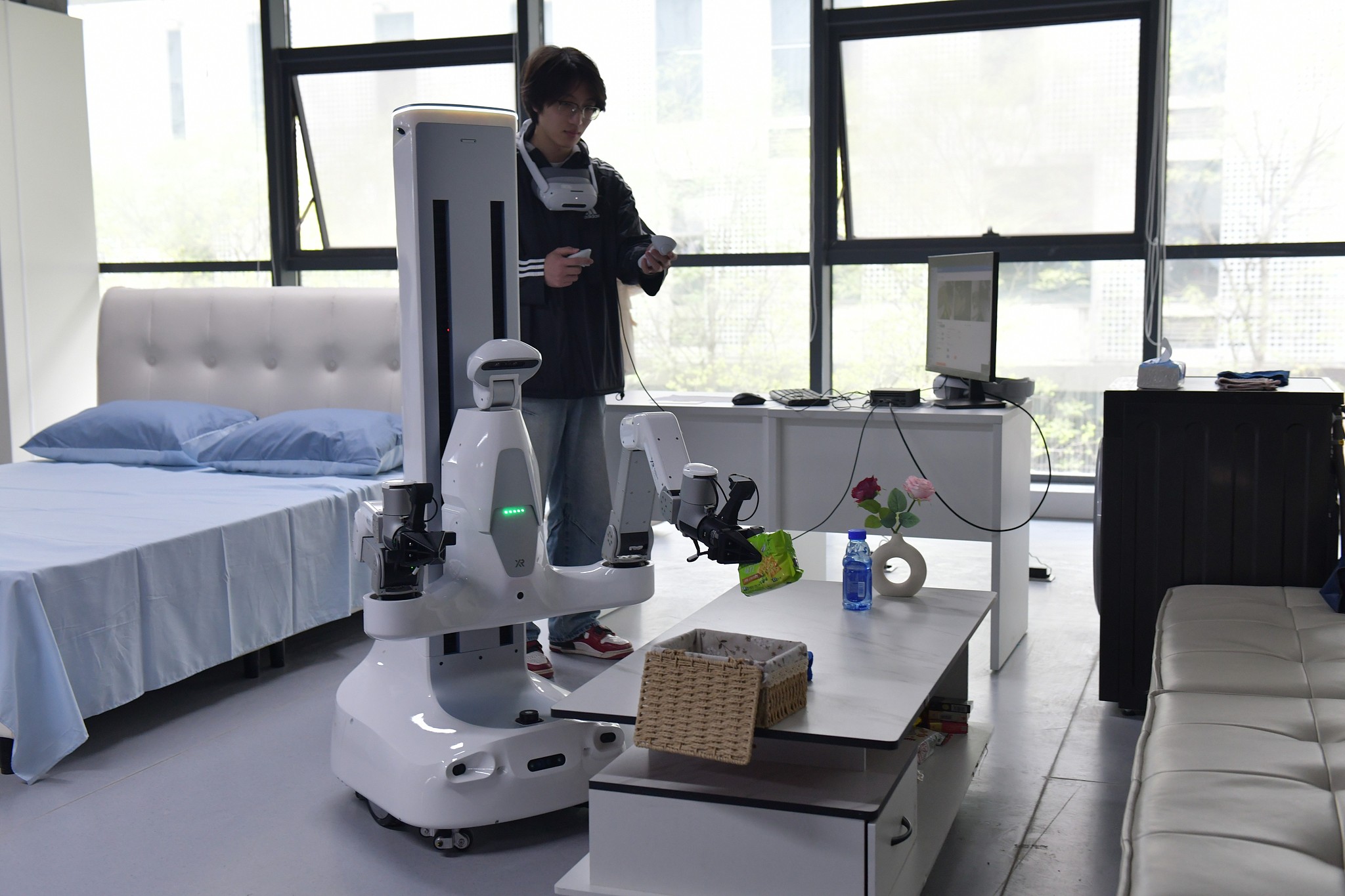 Data collectors train robots to clean a living room, Hefei, Anhui Province, China, April 13, 2026. /VCG