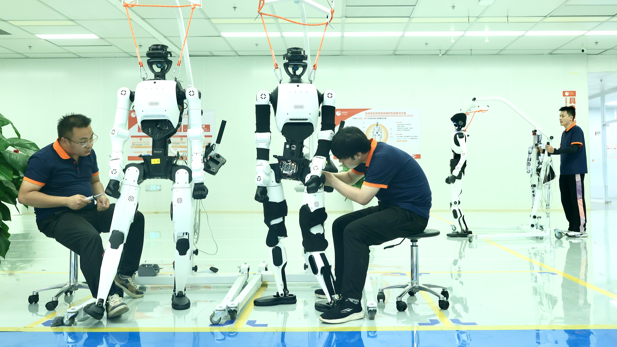 Workers assemble embodied AI robots at an AI super factory in Yizhuang, Beijing, China, June 16, 2026. /VCG