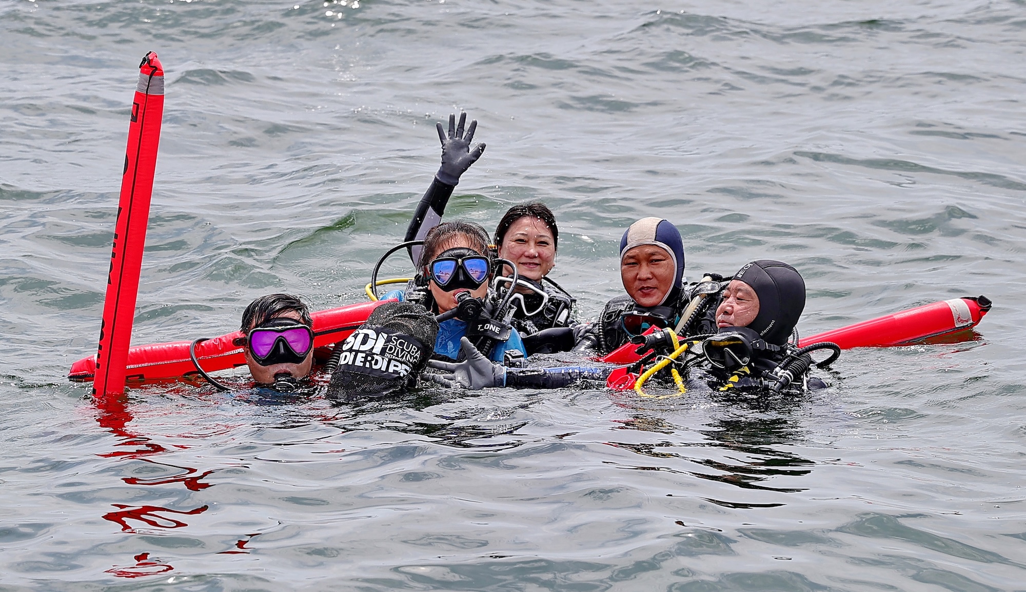 Volunteer divers display the marine debris they collected during the 