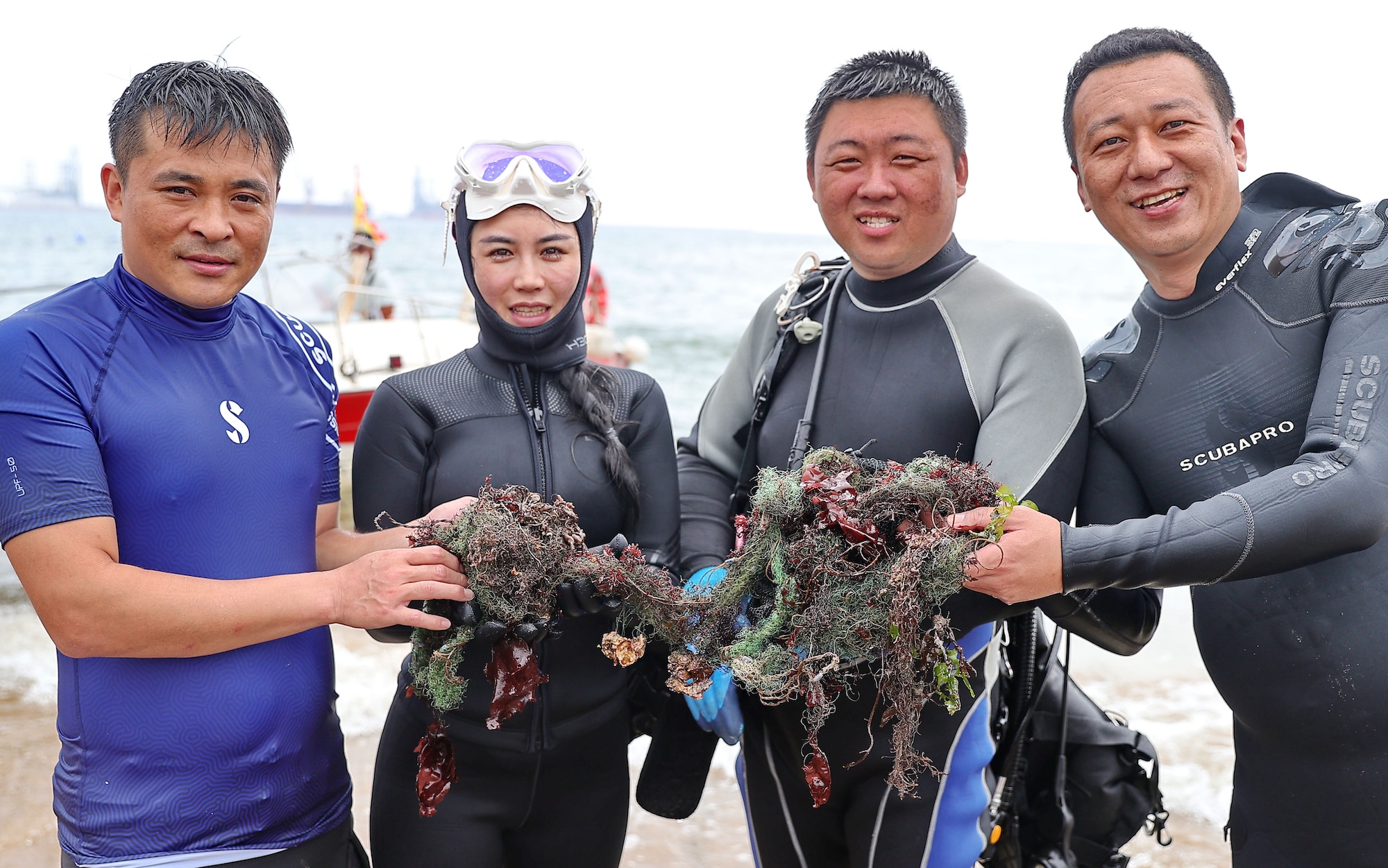 Volunteer divers display the marine debris they collected during the 