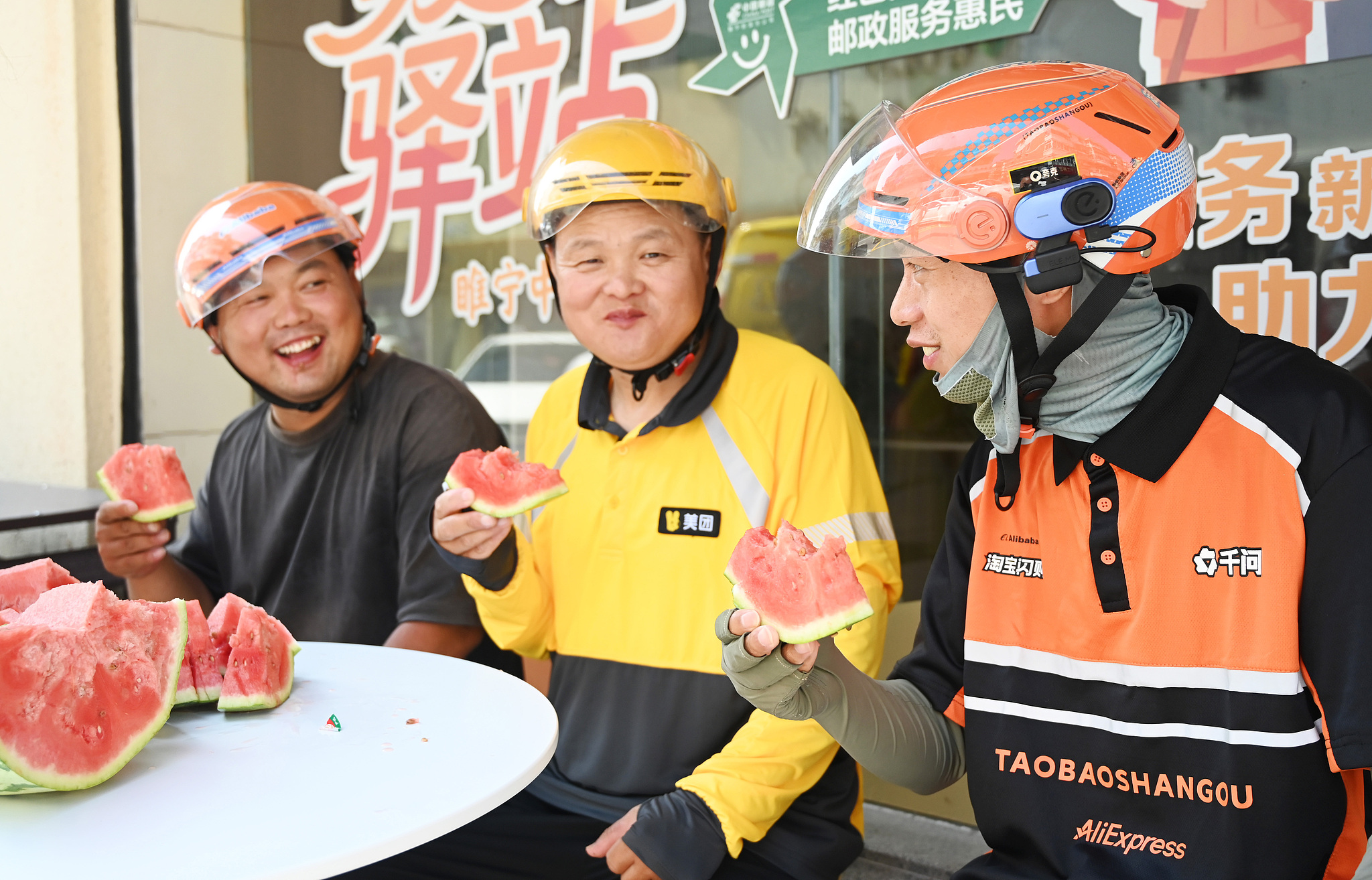 Delivery riders enjoy watermelons at a rest station in Xuzhou City, east China's Jiangsu Province, July 27, 2026. /VCG