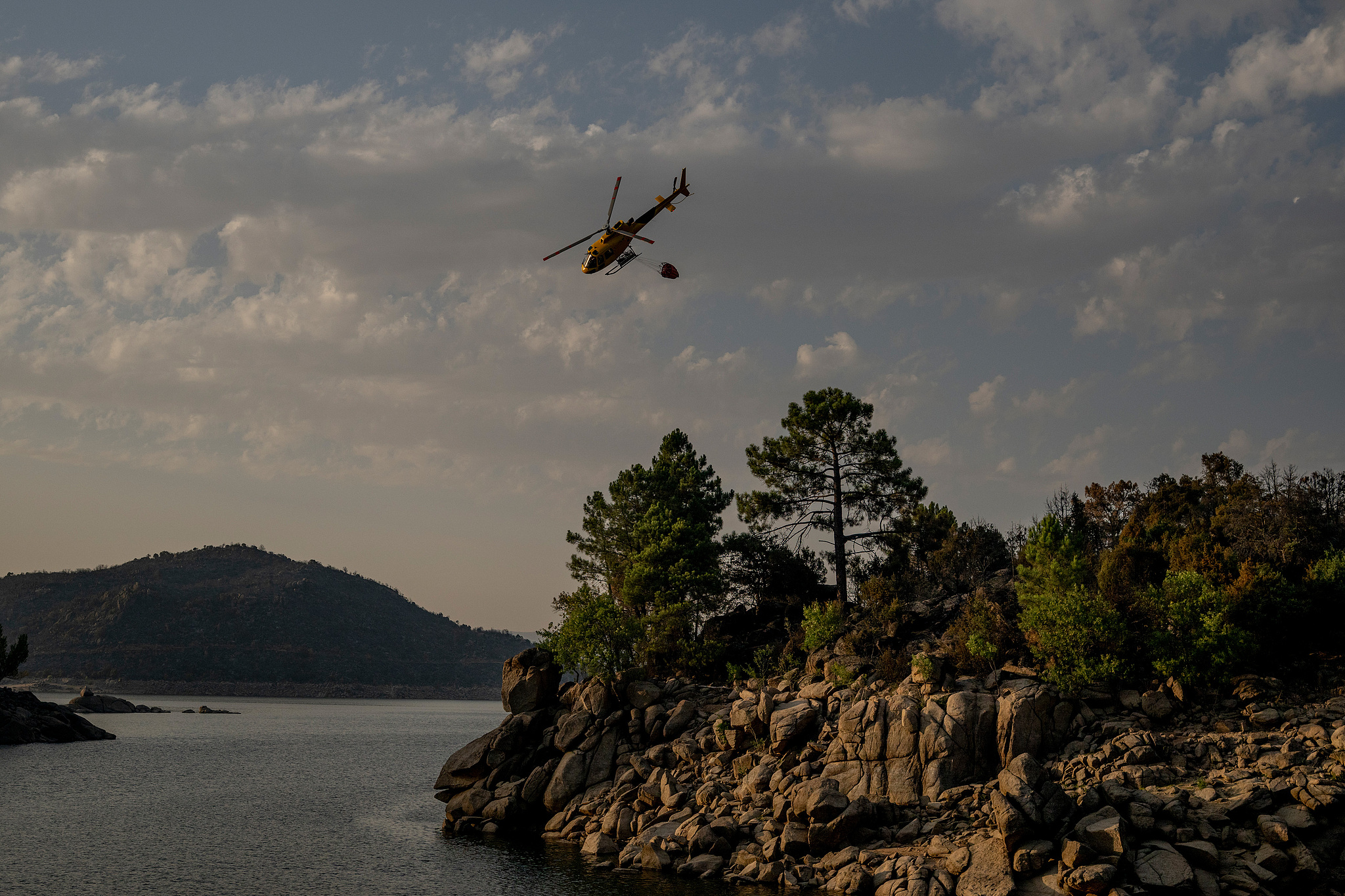 A firefighting helicopter flies over a wildfire in the Iruelas Valley Nature Reserve in the Avila region, Spain, July 30, 2026. /VCG
