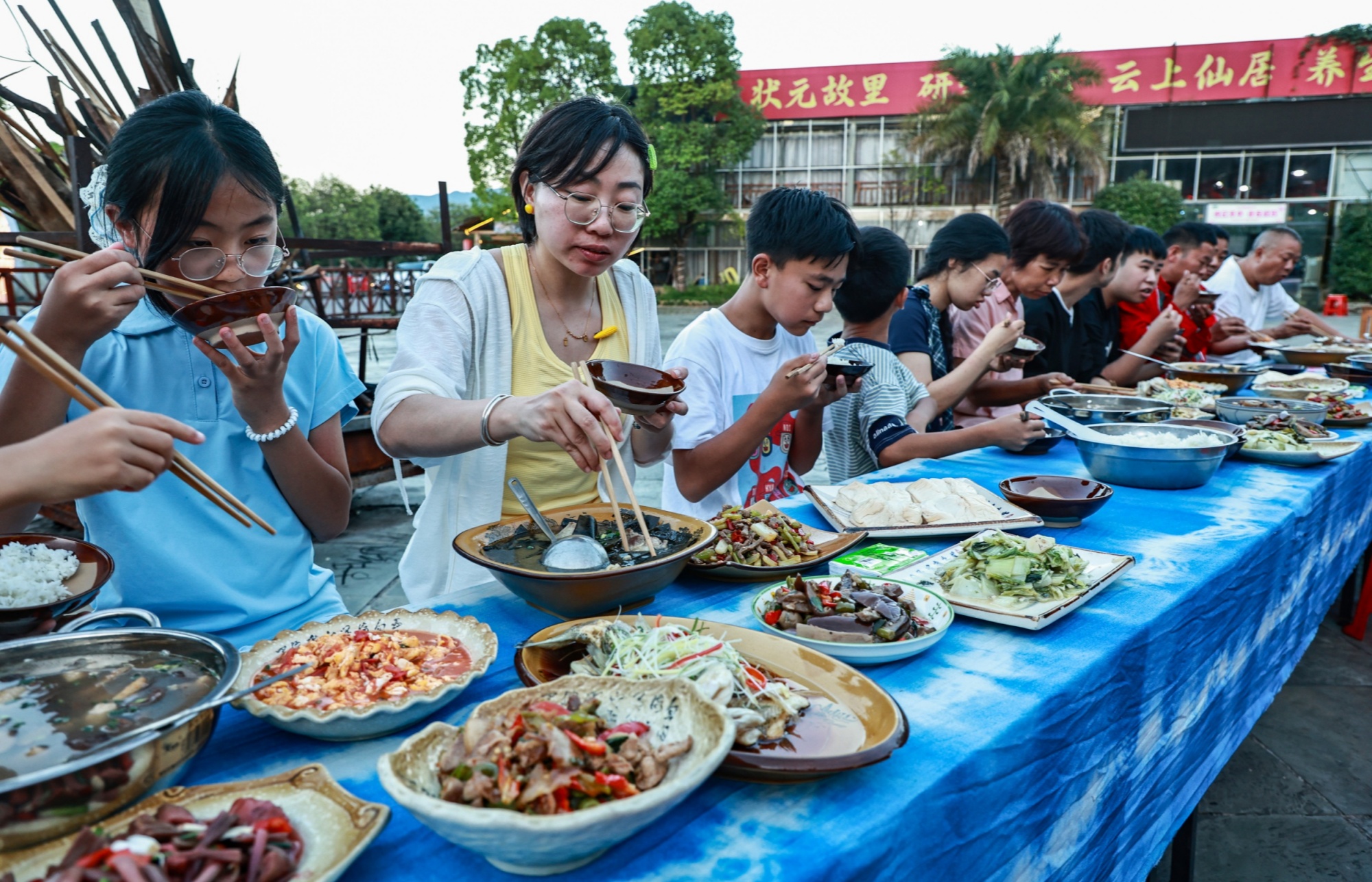 Guests feast at a long-table banquet in Yinjiang Tujia and Miao Autonomous County in southwest China's Guizhou Province on July 21, 2026. /Tongren Media Convergence Center