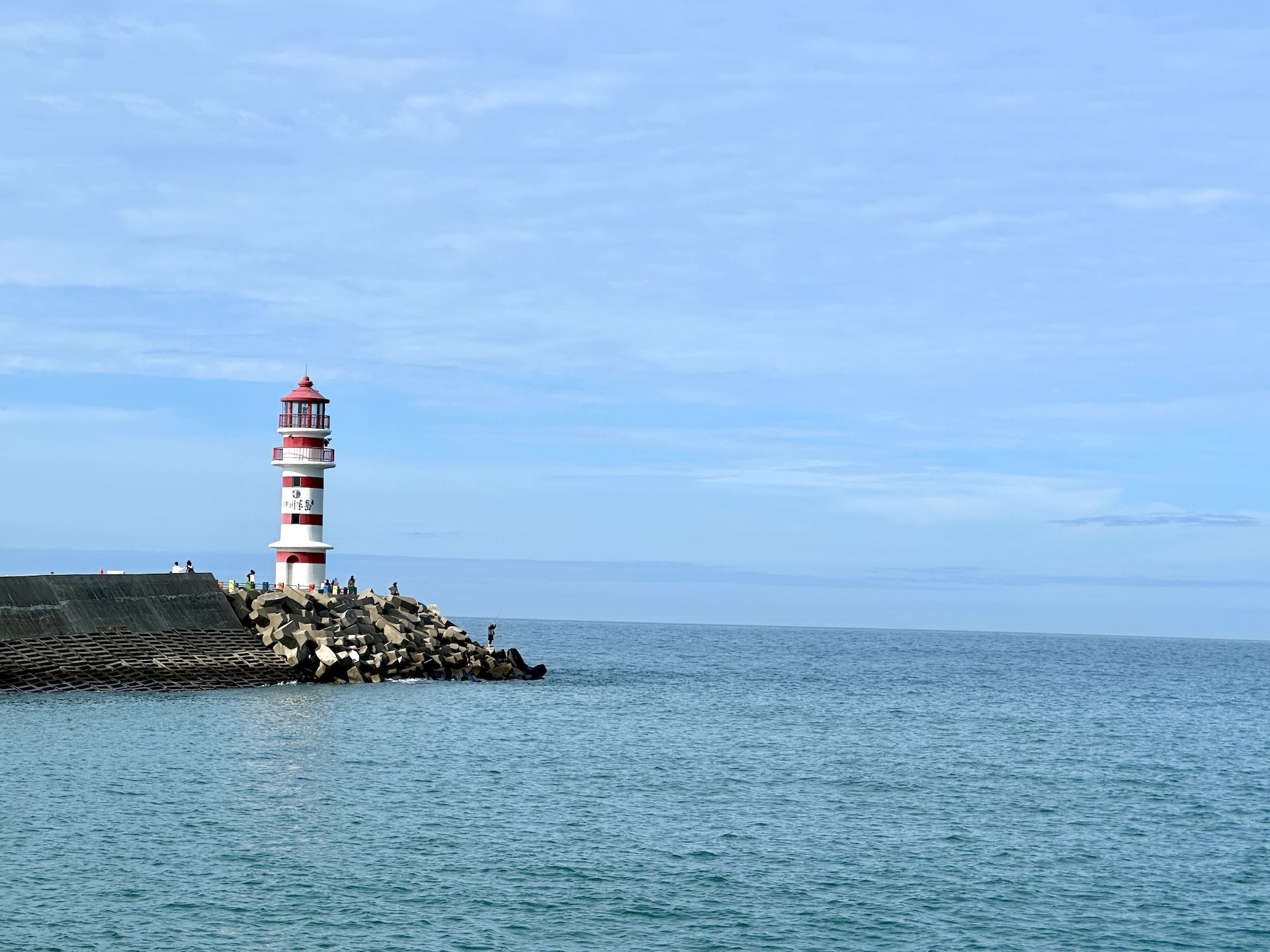 A red-and-white striped lighthouse stands against the azure sea and sky on Shenzhou Peninsula in Wanning, Hainan Province on July 13, 2026. /CGTN