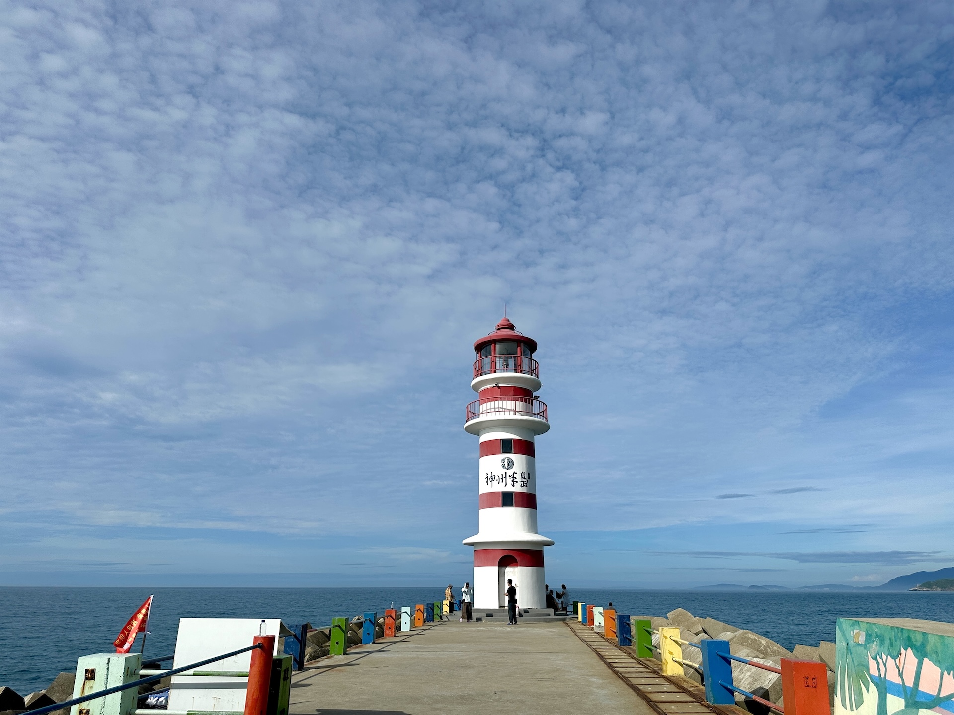 A red-and-white striped lighthouse stands against the azure sea and sky on Shenzhou Peninsula in Wanning, Hainan Province on July 13, 2026. /CGTN