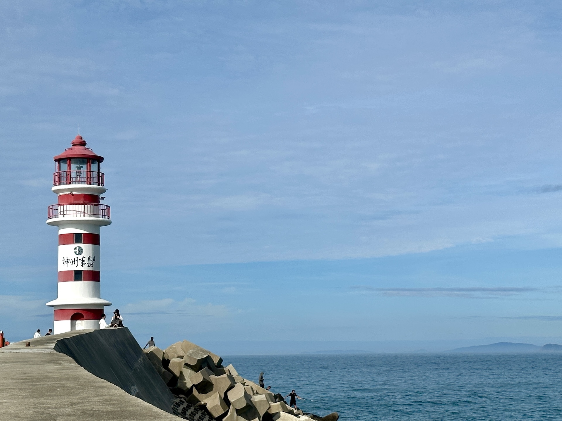 A red-and-white striped lighthouse stands against the azure sea and sky on Shenzhou Peninsula in Wanning, Hainan Province on July 13, 2026. /CGTN