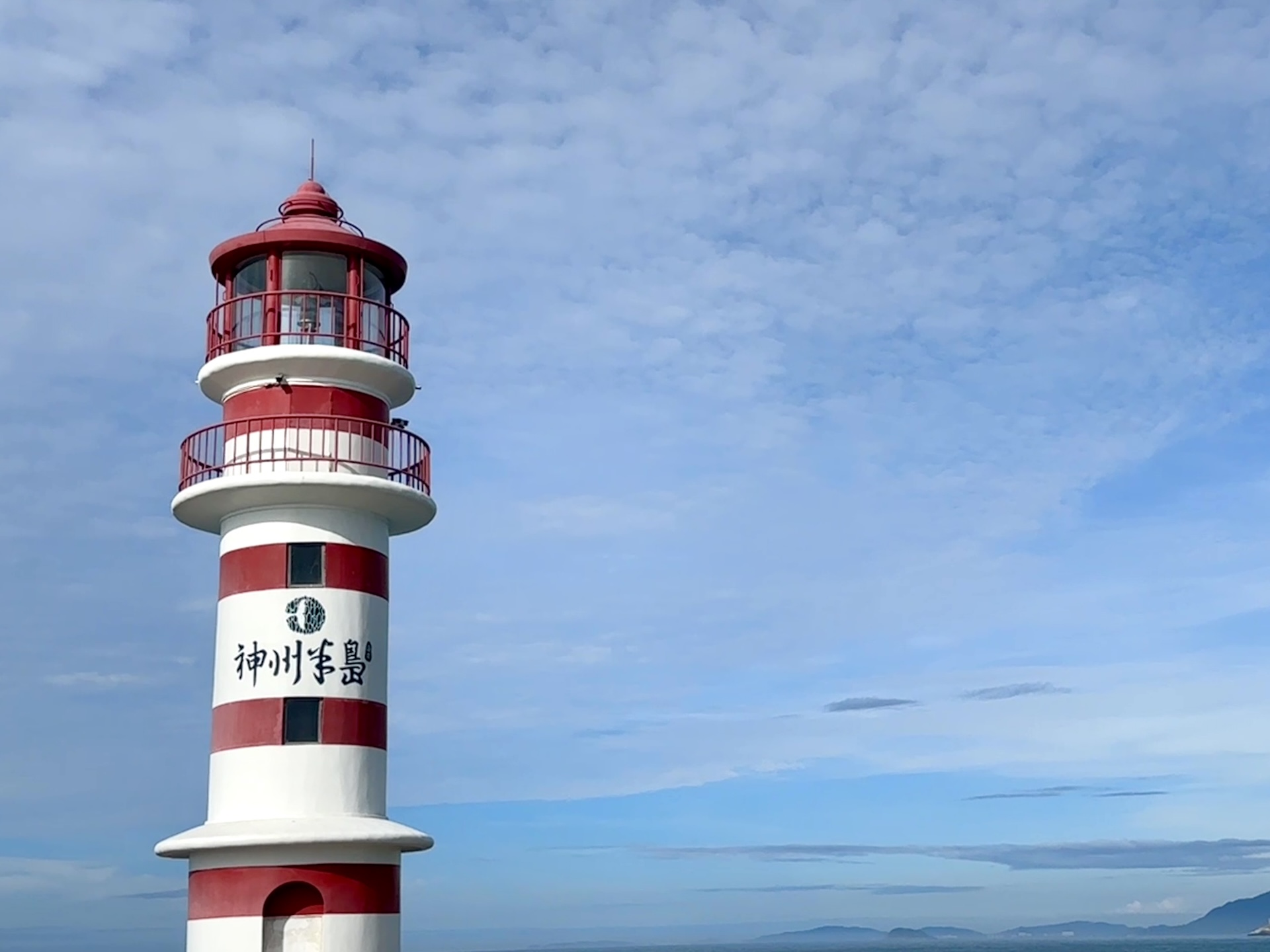 A red-and-white striped lighthouse stands against the azure sea and sky on Shenzhou Peninsula in Wanning, Hainan Province on July 13, 2026. /CGTN