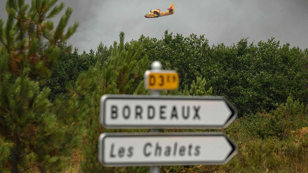 An aircraft flies over a wildfire near Lanton, east of the Arcachon Bay, west of Bordeaux, during wildfires in the Gironde region, southwestern France, July 29, 2026. /VCG
