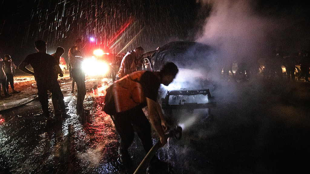 Palestinian Civil Defense personnel extinguish a fire in a destroyed car following an Israeli airstrike on Al-Rashid Road next to the beach in southern Gaza City, August 3, 2026. /VCG