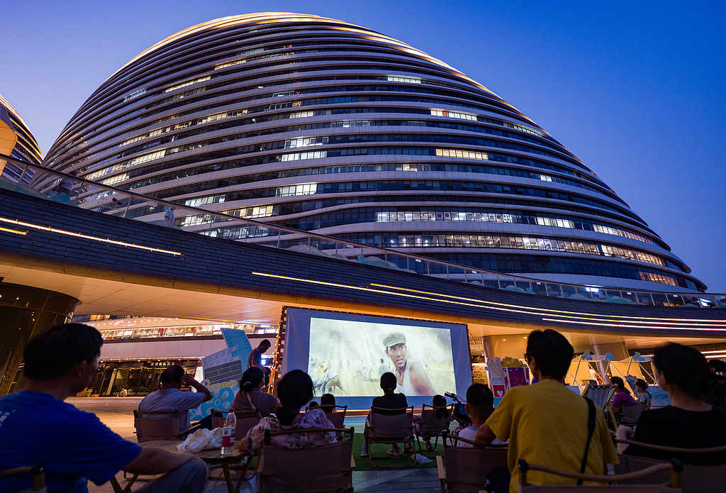 Residents view a film at an outdoor screening at Wangjing SOHO Plaza in Beijing on August 6, 2026. /VCG