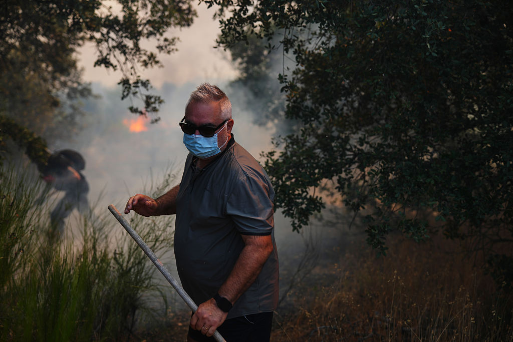 Volunteers try to help stop a wildfire from advancing in San Martin de Valdeiglesias, west of Madrid, Spain, July 26, 2026. /VCG