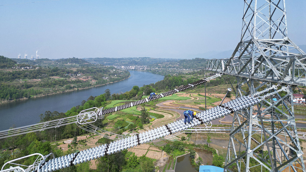 State Grid workers inspect transmission towers as the Chongqing section of the ±800 kV Hami-Chongqing ultra-high-voltage transmission project completes line inspection, Chongqing Municipality, China, April 8, 2025. /VCG
