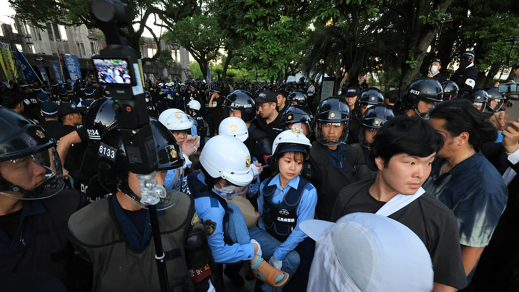 Police officers remove anti-war activists at Hiroshima Peace Memorial Park in Hiroshima City, Hiroshima Prefecture, Japan, August 6, 2026. /VCG