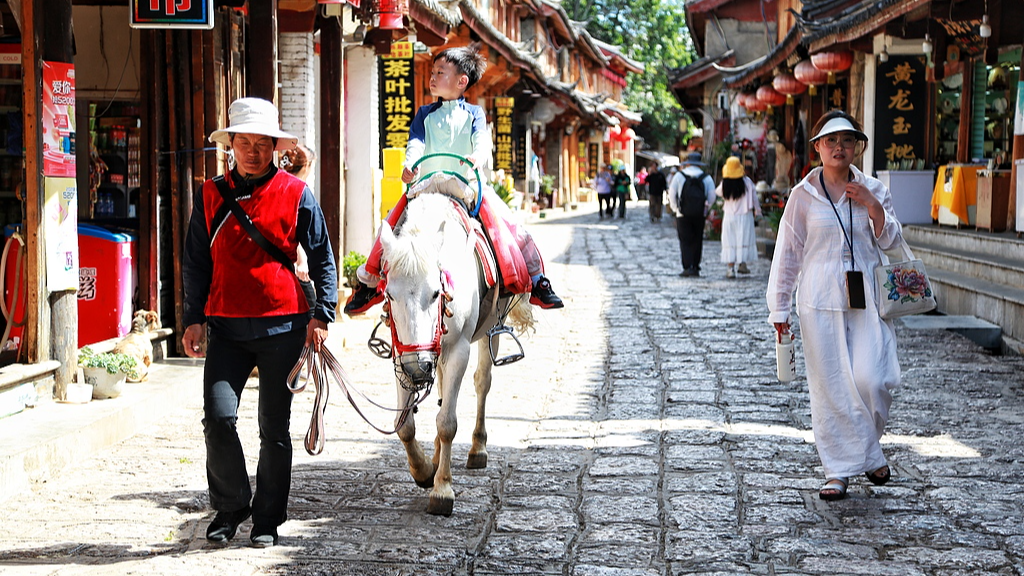Tourists walking along a traditional street in Lijiang, Yunnan Province, China, May 24, 2026. /VCG