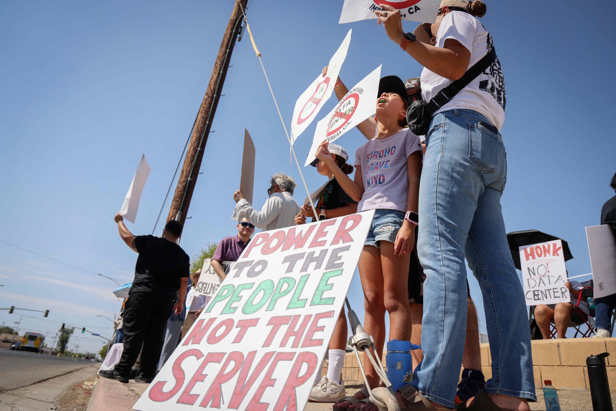 Demonstrators wave signs during a nationwide protest against AI data center expansion in Imperial, California, US, July 18, 2026. /VCG