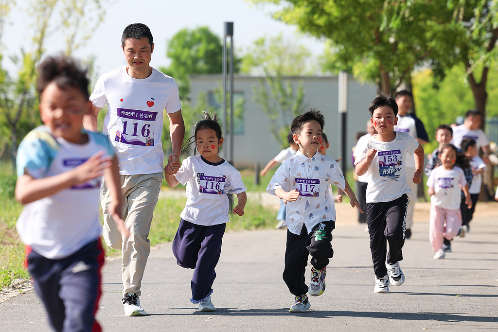 Children from a local kindergarten and their parents participate in a parent-child long-distance run in Yinghai Park, Zhengding County, Shijiazhuang City, north China's Hebei Province, April 30, 2026. /VCG