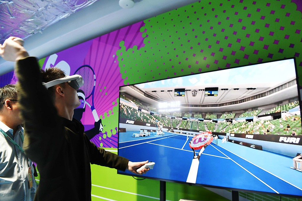 A visitor experiences an immersive virtual tennis game at the 2026 Zhongguancun Forum Annual Conference in Beijing, China, March 24, 2026. /VCG