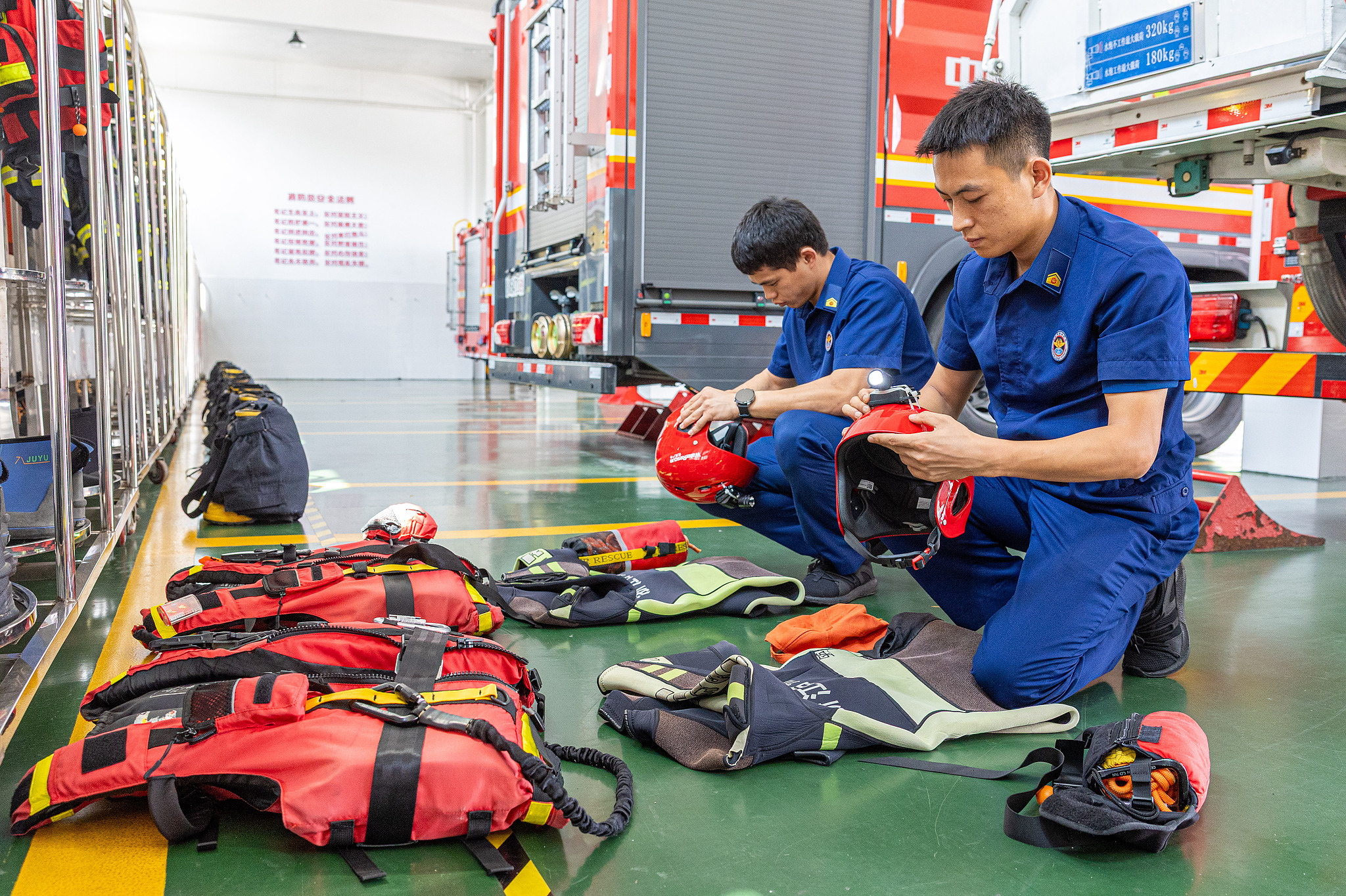 Firefighters at the Chengxi Fire Station in Wenling, Zhejiang Province, inspect water-rescue protective equipment, including helmets and life jackets, as they make full preparations for Typhoon Dolphin, August 7, 2026. /VCG
