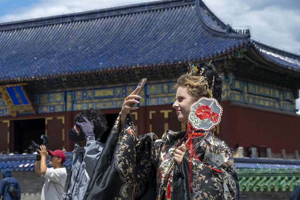 A foreign tourist takes photos in the Temple of Heaven in Beijing, China, June 9, 2026. /VCG