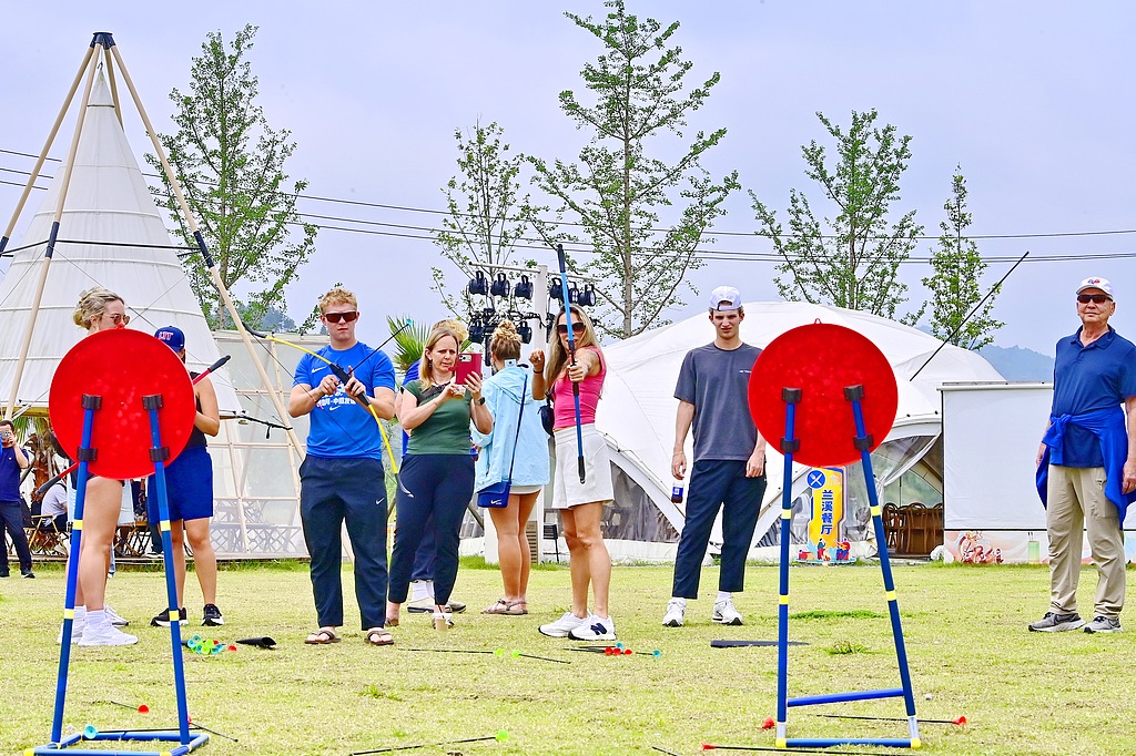 Foreign tourists experience a traditional archery game at a rural tourist attraction in Ganzhou City, east China's Jiangxi Province, May 10, 2026. /VCG