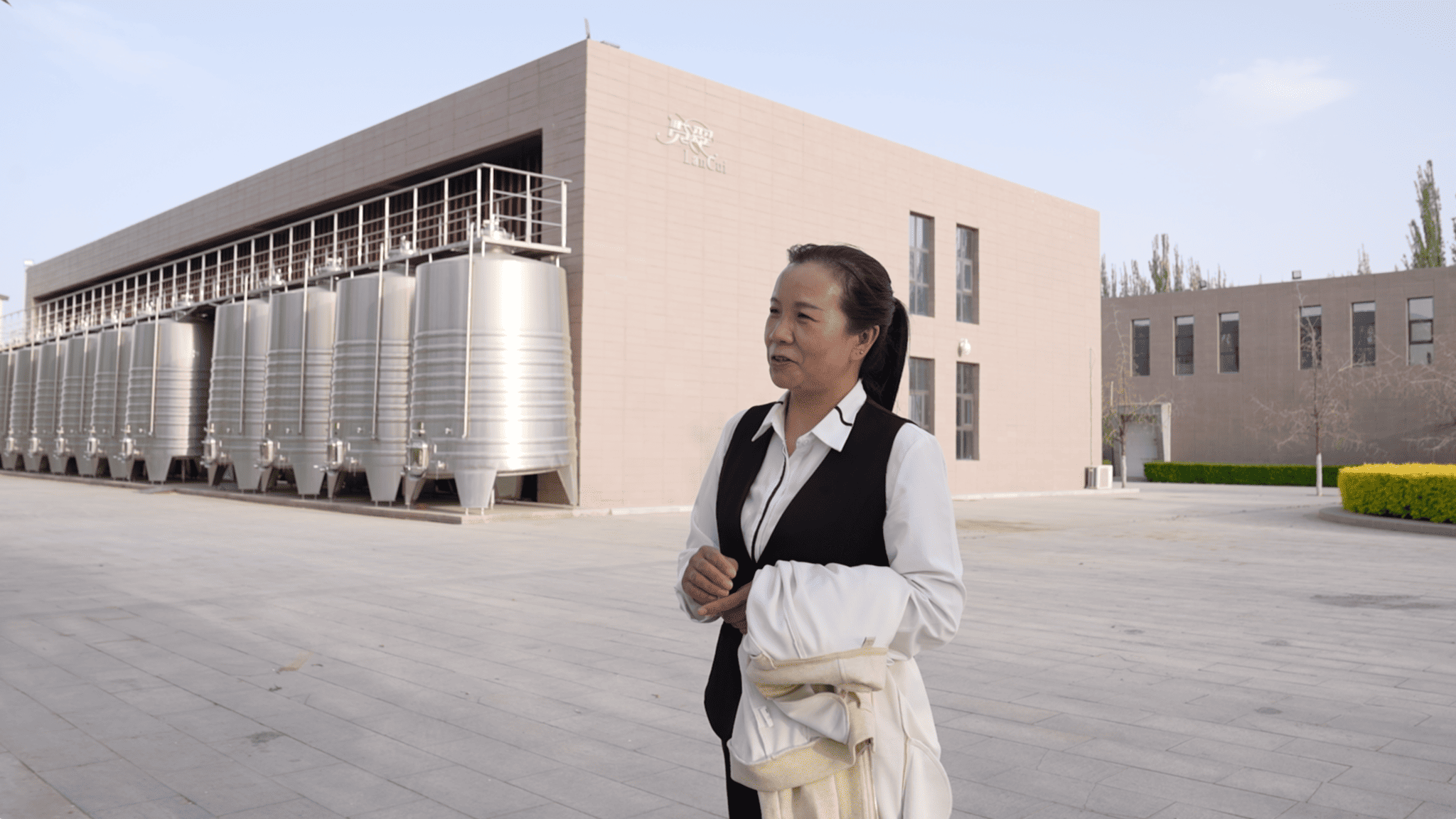 Liu Li, on the grounds of the vineyard where she works, is frequently featured in media reports about her new hometown of Minning in Ningxia Hui Autonomous Region. April 22, 2026. CGTN.