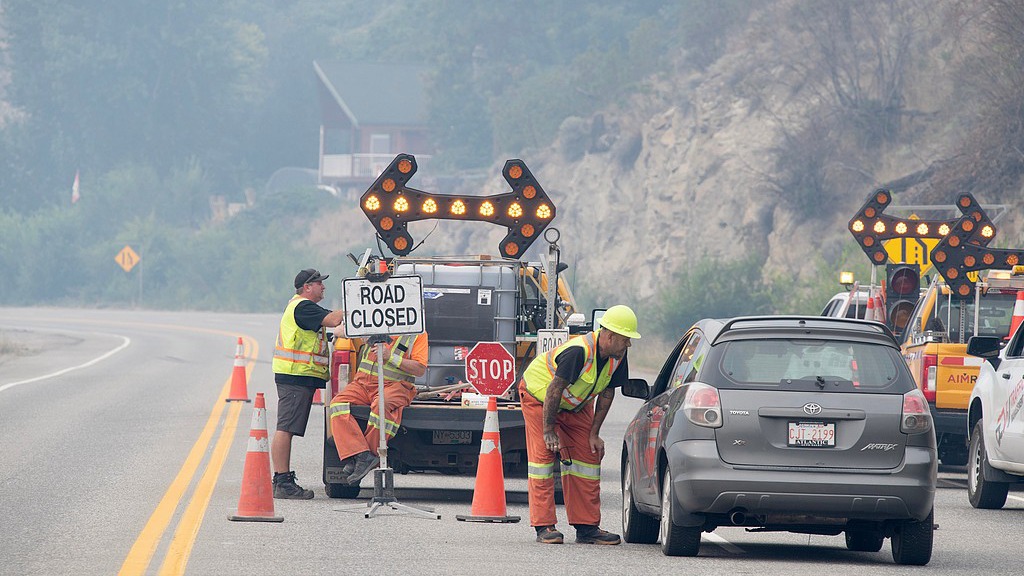 Emergency crews talk to the driver of a car at a closed section of Highway 97 south of Peachland, British Columbia, August 8, 2026. /VCG 