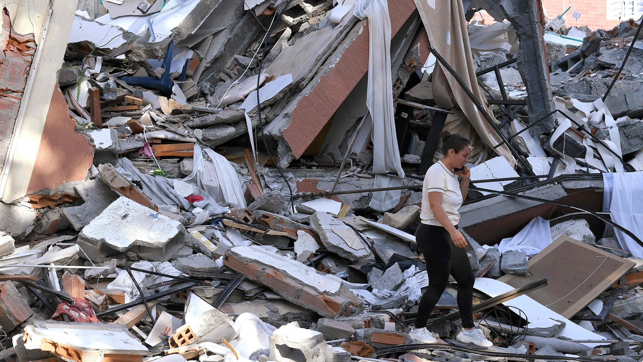 A woman walks past the rubble of a collapsed building after an earthquake in Pereira, Colombia, August 10, 2026. /VCG