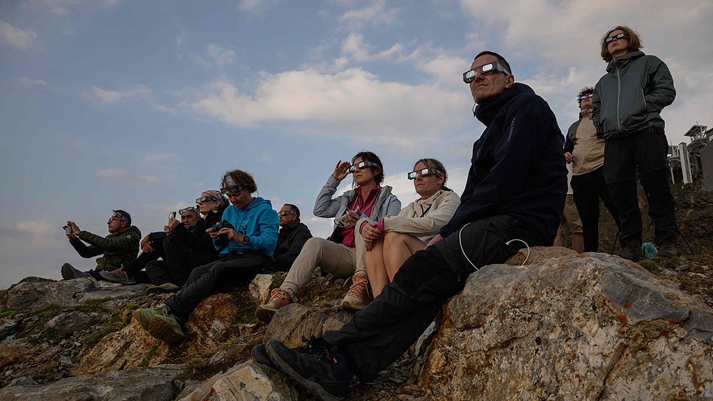 People watch as the moon passes over the sun's horizon during a partial solar eclipse at the summit of Pic du Midi, France, August 12, 2026. /VCG