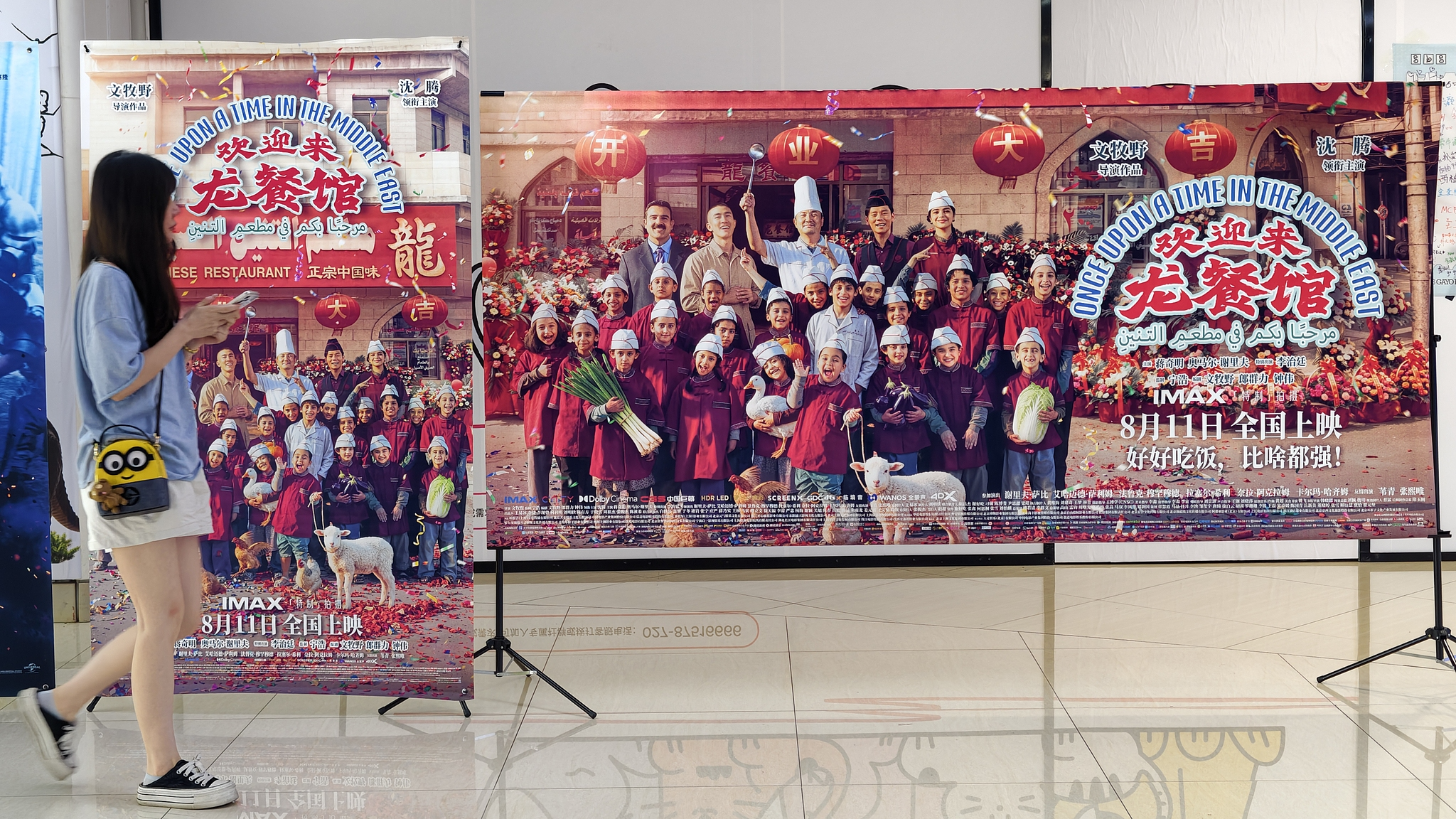 People walk in front of posters for the film 