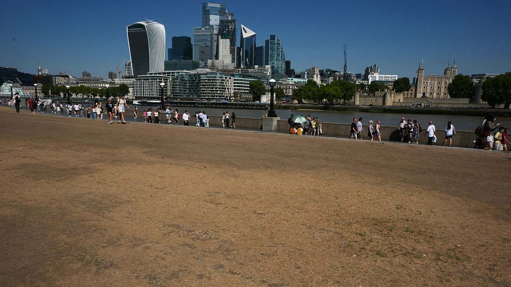 People walk past dried grass alongside the River Thames during a heatwave in London, the UK, August 13, 2026. /VCG 