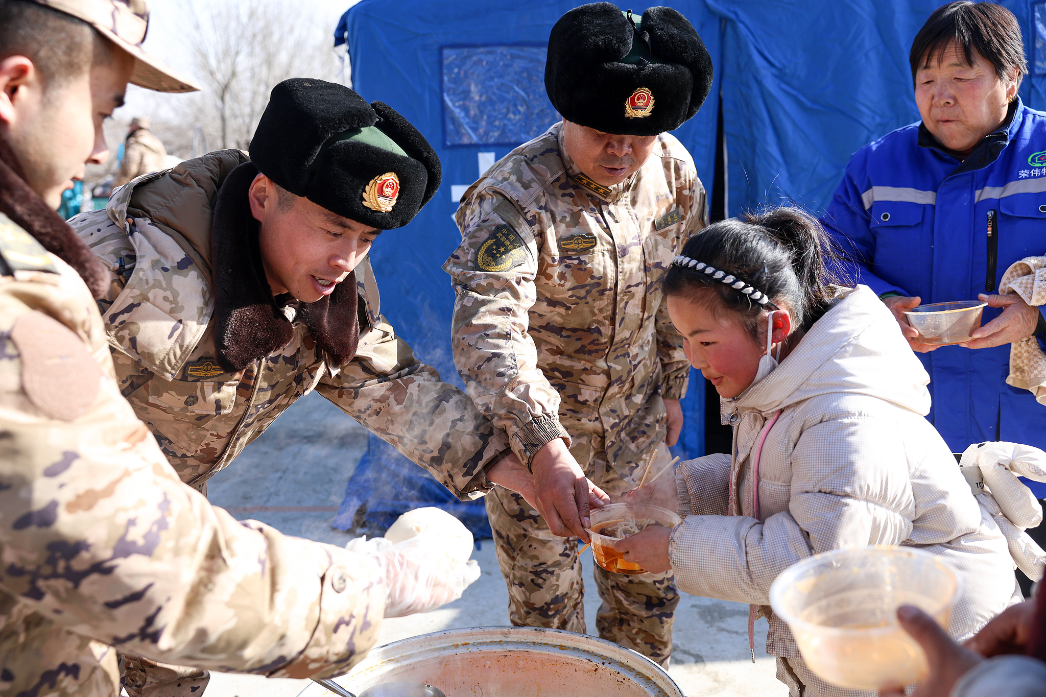 Residents affected by an earthquake in Linxia Hui Autonomous Prefecture, Gansu Province are provided with hot food on December 21, 2023. /VCG