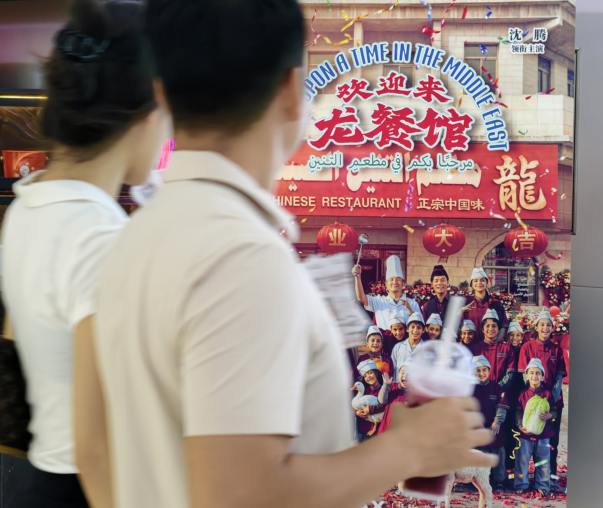 People walk past a poster of the film 