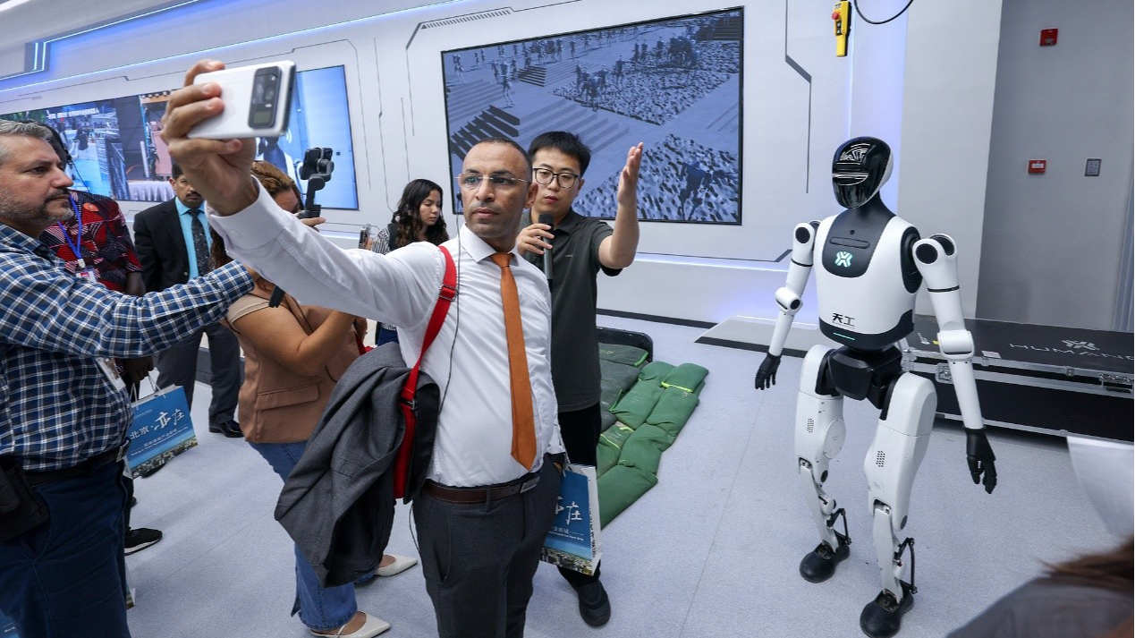 A journalist takes a selfie with the Tiangong humanoid robot in Beijing, China, September 29, 2025. /CFP