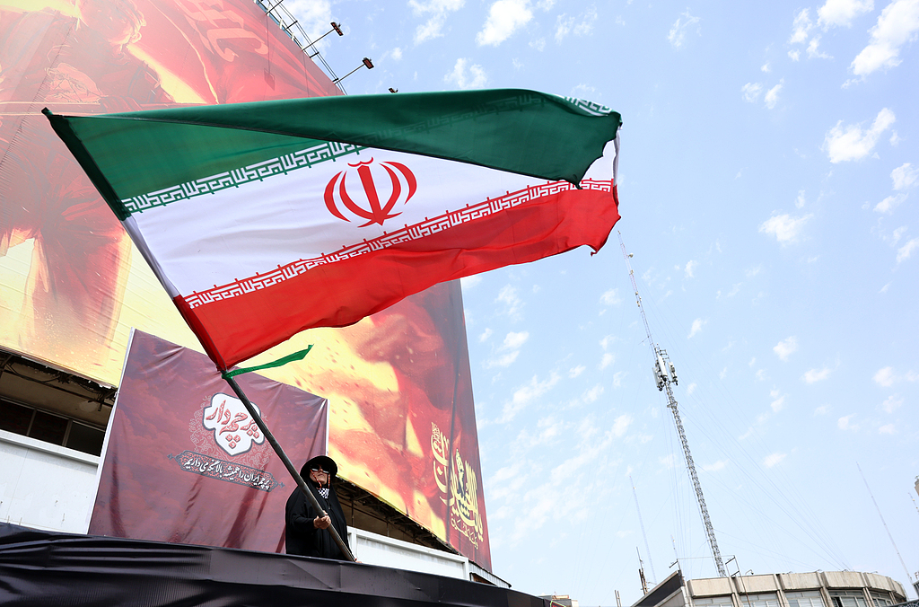 An Iranian woman flies Iran's national flag at the Valiasr Square in Tehran, Iran, August 17, 2026. /VCG