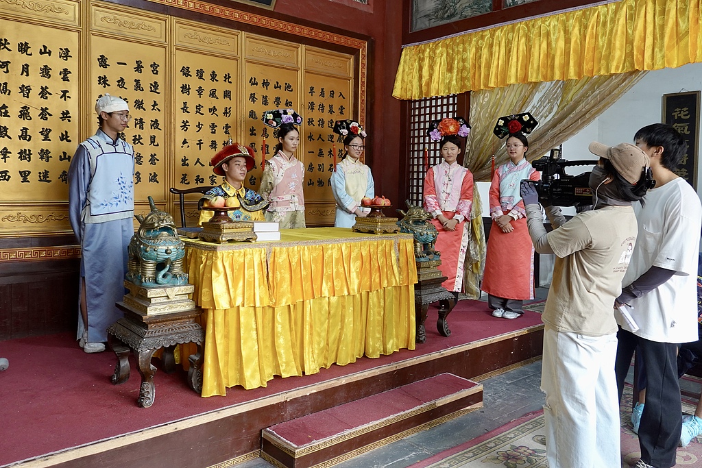Tourists take part in a short-drama filming experience at Hengdian World Studios in Zhejiang Province on August 13, 2026. /VCG