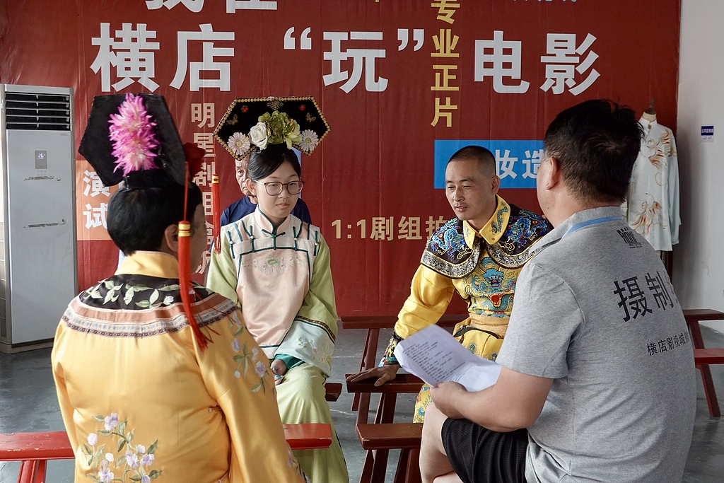 Tourists take part in a short-drama filming experience at Hengdian World Studios in Zhejiang Province on August 13, 2026. /VCG