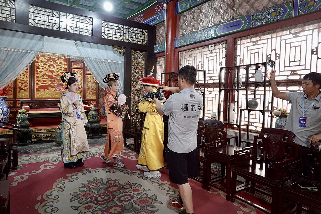 Tourists take part in a short-drama filming experience at Hengdian World Studios in Zhejiang Province on August 13, 2026. /VCG