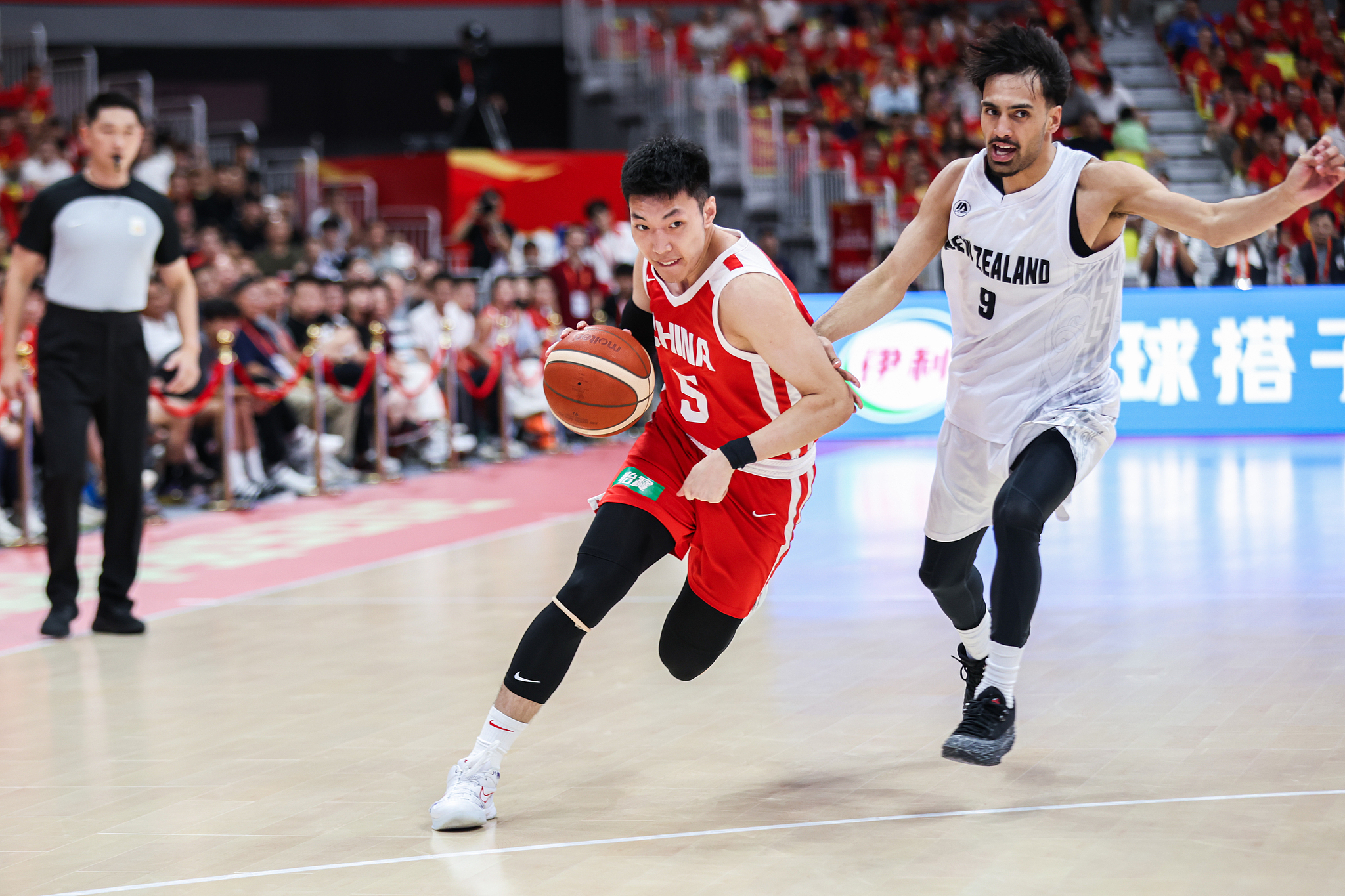 China guard Liao Sanning (#5) drives against New Zealand forward James Moors in a warmup game in Foshan, south China's Guangdong Province, August 17, 2026. /VCG